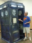 Man in Superman shirt standing by a TARDIS